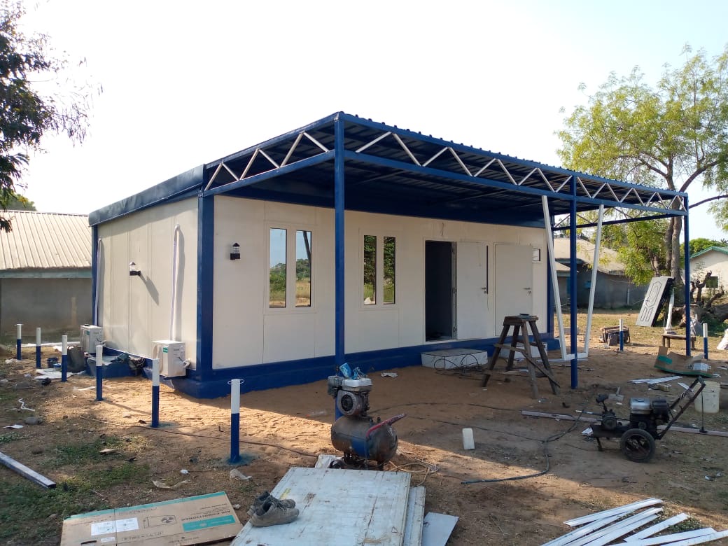 Panel building with a steel roof structure over the front