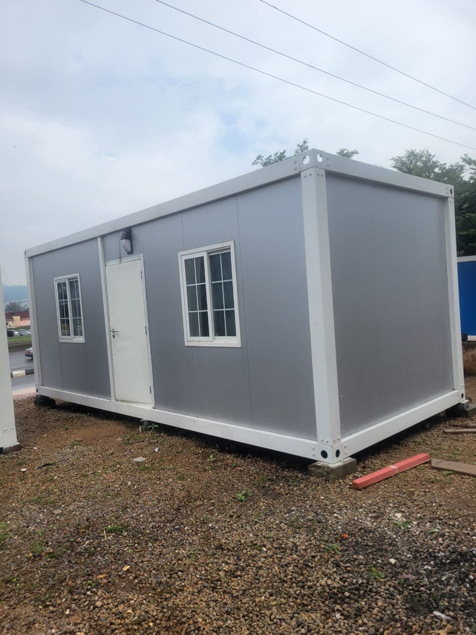 Grey container office unit with two windows and a steel door